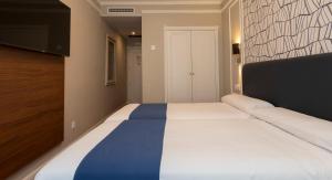 Postel nebo postele na pokoji v ubytování Hotel Corona de Castilla Burgos