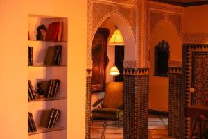 a living room with a chair and a room with books at LUXURY apartment in Marrakesh