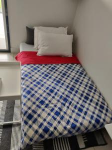 a bed with a blue and white blanket on it at Au coin tranquille in Champigny-sur-Marne +18 photos