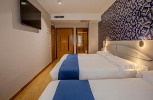 Postel nebo postele na pokoji v ubytování Hotel Corona de Castilla Burgos