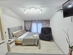 a small bedroom with a bed and a chair at Grey Studio in Chişinău