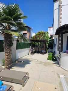 un patio con una palmera y un banco en Villa à Turgutreis, en Bodrum City