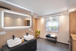 ein Badezimmer mit zwei Waschbecken und einem großen Spiegel in der Unterkunft Appartment Antilope im Würmtal in Gräfelfing + 15 Fotos