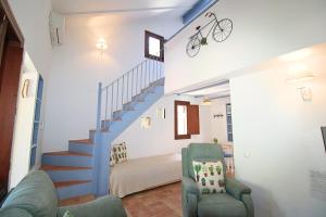 a living room with a staircase with a bike on the wall at Casa Garalp - Only Adults by SIERRA VIVA in Aracena