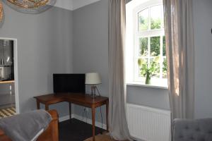 a room with a desk with a television and a window at Hof Reinecke in Hannover