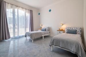 a bedroom with two beds and a window at LUXURY HOUSE Olbia center with private garden in Olbia