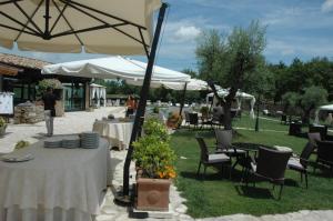 a table with plates and an umbrella in a yard at Agriturismo Campo Antico in Orte