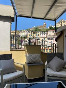 a balcony with two chairs and a view of buildings at Torre Anna in Riomaggiore