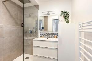 a bathroom with a shower and a sink and a mirror at Part-Dieu - Option Parking in Lyon +16 photos