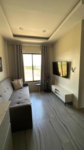 a living room with a couch and a flat screen tv at Kristinas Aparthotel Kabankalan in Kabankalan
