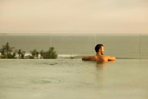 a man laying in the water in a swimming pool at Holiday Inn Resort Bali Canggu by IHG in Canggu