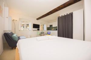 a bedroom with a large white bed and a couch at CasaViva - Elegant Seaview Studio in Camogli in Camogli