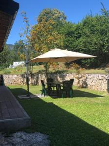 un tavolo e sedie sotto un ombrellone nell'erba di bed an breakfast Aurora a Trento