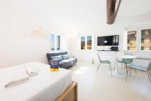 a white room with a bed and a table and chairs at CasaViva - Elegant Seaview Studio in Camogli in Camogli