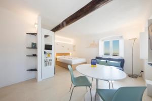 a room with a table and chairs and a bed at CasaViva - Elegant Seaview Studio in Camogli in Camogli