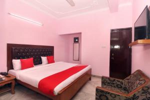 a bedroom with a large bed and a chair at Hotel O Simran in Chandīgarh