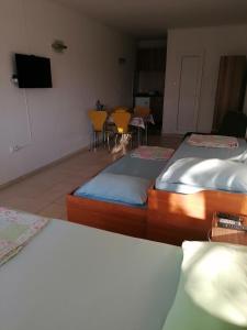 a room with two beds and a table and chairs at Apartmani Lav in Sutomore