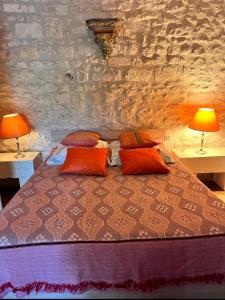 a bedroom with a bed with two lamps on two tables at La Laiterie du Logis in Chaniers