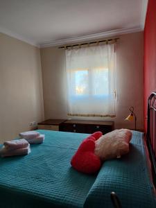 un dormitorio con dos animales de peluche tirados en una cama en Apartamentos San Miguel 2, en Almerimar