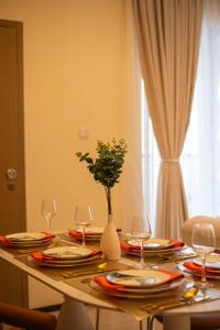 a table with plates and glasses and a vase with flowers at GTC Residence, Luxurious Living in The Heart of Nairobi, Westlands in Nairobi