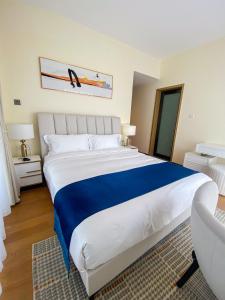 a bedroom with a large bed with a blue blanket at GTC Residence, Luxurious Living in The Heart of Nairobi, Westlands in Nairobi +7 photos