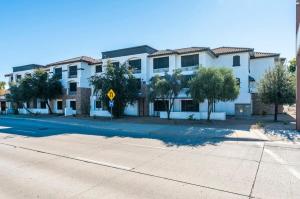 a large white building with a street sign in front of it at Metro Extended Stays - Tempe - 2 Full Beds in Tempe