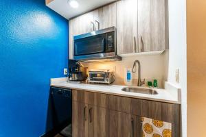 a kitchen with a sink and a microwave at Metro Tempe Extended Stay - 2 Full Beds in Tempe +20 photos
