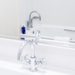 a bathroom with a sink and a mirror at Golden Sands in St Brelade