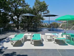 a group of chairs and tables and umbrellas at Apartmani Lav in Sutomore