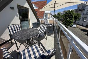 - Balcón con sillas, mesa y sombrilla en Ferienwohnung Käte, en Warnemünde