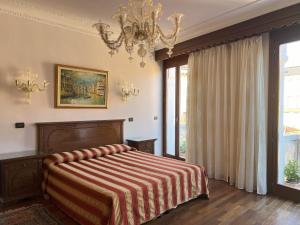 una camera da letto con un letto e un lampadario di Hotel San Luca Venezia a Venezia