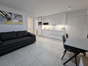 a living room with a black couch and a table at SeaView apartment Mirjam with Jacuzzi in Portorož