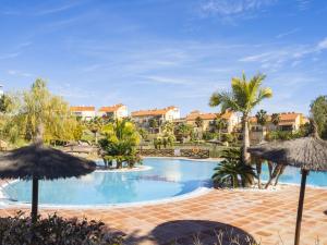 ein Pool in einem Resort mit Sonnenschirmen in der Unterkunft Cubo's Apartment Sol Andalusi in Alhaurín de la Torre