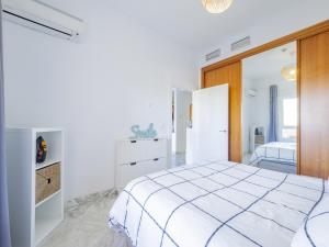 ein weißes Schlafzimmer mit einem Bett und einem Spiegel in der Unterkunft Cubo's Apartment Sol Andalusi in Alhaurín de la Torre + 33 Fotos