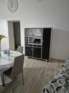 a dining room with a table and a clock on the wall at Residenza La Torre in Foggia