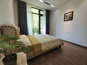 une chambre avec un lit et une plante en pot dans l'établissement Sunshine villa, à Ấp Long Hồ Hạ
