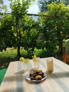 a table with a plate of donuts and two drinks at Balatoni Mandala Vendégház in Balatonszemes