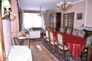 a dining room with a red table and chairs at Chez anne in Charleville-Mézières