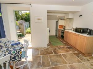 a kitchen with a table and a kitchen with a table and chairs at Cobbles Cottage in Heptonstall