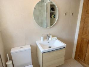a bathroom with a toilet and a sink and a mirror at Cobbles Cottage in Heptonstall