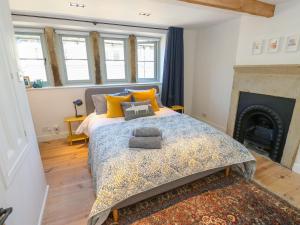 a bedroom with a bed and a fireplace at Cobbles Cottage in Heptonstall