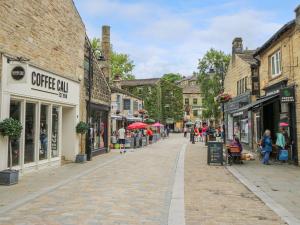 a cobblestone street in an old town with shops at Cobbles Cottage in Heptonstall