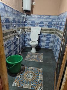 une salle de bain avec toilettes et un seau vert dans l'établissement Greenland Resort and Family Restaurant, à Munirābād