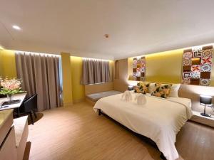 a hotel room with a bed and a desk at Kastel Bangkok Hotel in Bangkok