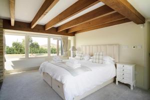 une chambre avec un grand lit blanc et une fenêtre dans l'établissement Willersey Road Farm, à Broadway