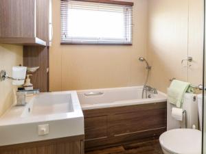 a bathroom with a sink and a tub and a toilet at Lodge 26, Fishing Lakes in Stowmarket +19 photos