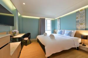 a hotel room with a large bed and a flat screen tv at Kastel Bangkok Hotel in Bangkok