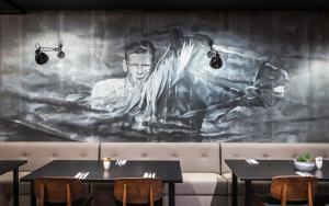 a painting of a man on a wall in a restaurant at Skuggi Hotel by Keahotels in Reykjavík
