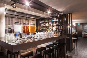 a bar with bar stools and bottles of alcohol at Skuggi Hotel by Keahotels in Reykjavík