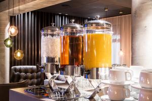 a table with three glass pitchers of orange juice at Skuggi Hotel by Keahotels in Reykjavík